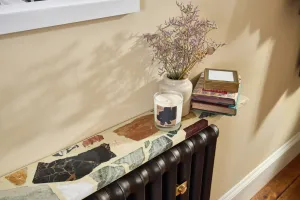 Interior lifestyle image of a Tickner stone and resin radiator shelf in a cream colourway above an Emmeline I 865mm in Bronze by Castrads.
