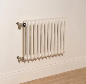 Wall-hung two-column Emmeline II cast iron radiator in Farrow & Ball Dimity No. 2008 with Satin Nickel valves, above a skirting board and oak floor.