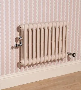 Plain wall-hung Mercury 3 Column cast iron radiator in Farrow & Ball Scallop No. 311 with chrome valves, against pink wavy-striped wallpaper.