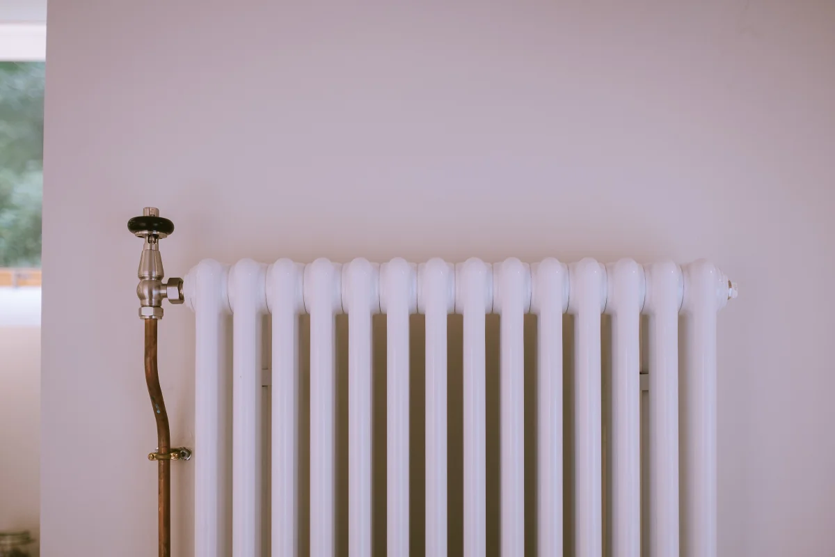 White Florence 3 Column steel radiator, wall-hung on a pale wall, with a Satin Nickel Windsor angled thermostatic valve on a copper pipe.