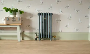 Grace 4 Column 760mm cast iron radiator on feet in Pencil, with Windsor valve, against seagull wallpaper beside a bench on an oak floor.