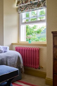 Interior lifestyle image of a Mercury 3 Column 560mm in Little Greene Carmine 189.