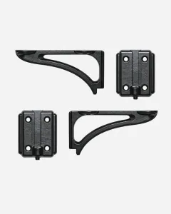 A pair of black cast iron Atlas shelf brackets with curved open arms, each shown beside its four-hole wall plate, on a pale grey background.