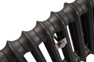 Close-up of the plain rounded columns of an Emmeline I cast iron radiator in Matt Black, with a satin nickel wall stay between sections.