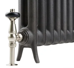 Close-up of the foot end of an Emmeline I cast iron radiator in dark graphite grey with a satin nickel angled valve and black head.