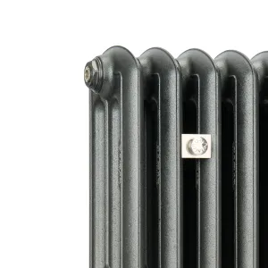 Close-up of the top corner of an Emmeline III cast iron radiator in a textured dark grey finish, with a plug and a square nickel wall stay.