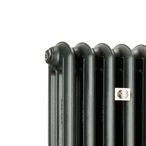 Close-up of the top corner of an Emmeline III cast iron radiator in a dark graphite finish, with a brass bleed plug and a square nickel plate on one column.