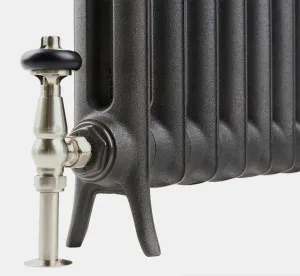 Close-up of the foot of an Emmeline I cast iron radiator in a textured dark grey finish, with a satin nickel angled valve and black head.