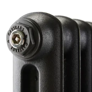 Close-up of the top corner of an Emmeline I cast iron radiator in a textured black finish, with a Castrads-stamped end cap and bleed valve.