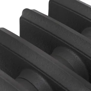 Close-up of plain Grace cast iron radiator sections in a textured matt black finish, showing the flat column faces and joining hubs.