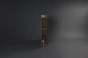 End view of a plain Mercury 4 Column 760mm cast iron radiator in Beaten Brass on feet, with a brass valve, against a dark grey backdrop.