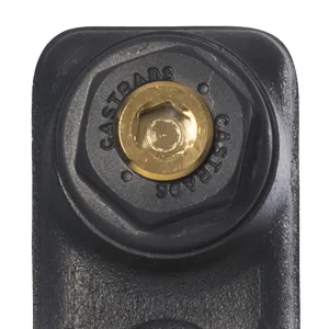 Close-up of a dark grey hexagonal end plug stamped CASTRADS with a brass centre, on the top of a cast iron radiator column.