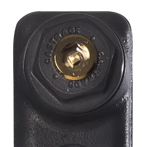 Close-up of a hexagonal end plug stamped CASTRADS with a brass bleed valve, on a plain cast iron radiator section in a dark grey finish.