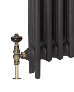 Close-up of the foot of a plain Mercury cast iron radiator in a dark textured finish with an antique brass angled valve and wooden head.