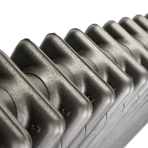 Close-up of the rounded tops of plain cast iron radiator sections in a metallic pewter-grey finish, against a white background.