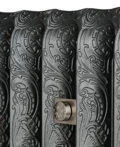 Close-up of ornate Rococo II cast iron radiator sections in a dark metallic finish, with a satin nickel wall stay embossed with a bee.