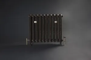 Ornate Rococo II 760mm cast iron radiator in a dark bronze finish on feet, with brass-coloured valves and wall stays, against a dark grey backdrop.