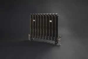 Ornate Rococo II cast iron radiator on feet in a dark bronze-toned finish, with brass valves and wall stays, on a dark grey backdrop.