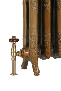 Close view of an ornate Rococo II cast iron radiator in Aged Gold on scrolled feet, with a brass angled valve and red-brown wooden head.