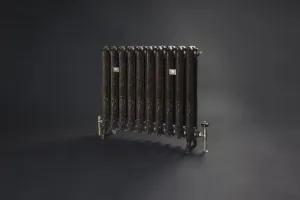 Ornate Rococo II cast iron radiator on feet in a dark bronze finish, with brass valves and wall stays, against a dark grey backdrop.