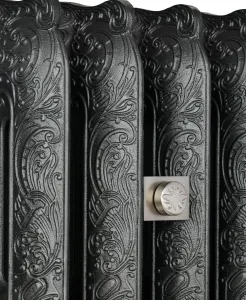 Close-up of ornate Rococo III cast iron radiator columns in a black iron finish, with a satin nickel square-plated fitting embossed with a bee.