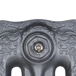 Close-up of the scrolled top of a Rococo III cast iron radiator in Black Iron, with a Castrads-stamped hexagonal bleed valve plug.