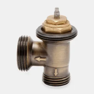 Niva angled thermostatic radiator valve body in Antique Brass, with threaded ends, flow arrows and a brass pin top, on a plain grey background.