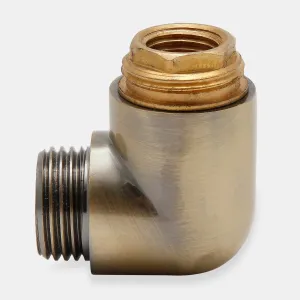 A 90-degree elbow fitting from a Niva radiator valve in Antique Brass, with a threaded male spigot and a raw brass hex coupling, on a pale grey background.