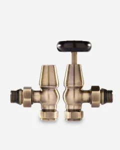 Pair of Windsor Angled Manual radiator valves in Antique Brass, one with a black wheel head and one with a lockshield cap, on a white background.