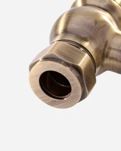 Close-up of the hexagonal compression nut and pipe inlet on a Windsor angled radiator valve in a brushed Antique Brass finish.