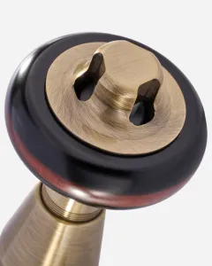 Close-up of a Windsor radiator valve in Antique Brass, showing the brushed brass cap set in a dark wooden head, on a white background.