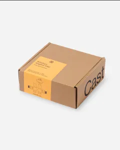 Closed kraft cardboard box with a yellow label reading Windsor Angled TRV, Unlacquered Brass, with a line drawing of the valve set, on a pale grey background.