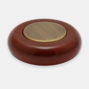 Close-up of a round, rich red-brown wooden valve head for a Windsor manual radiator valve, inset with a brushed Natural Brass disc, on a grey background.